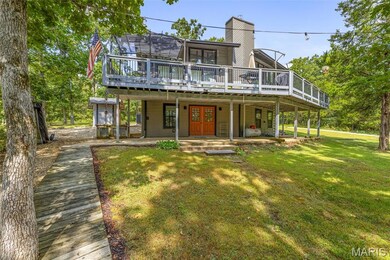 Back of property featuring a yard, a deck, and a chimney