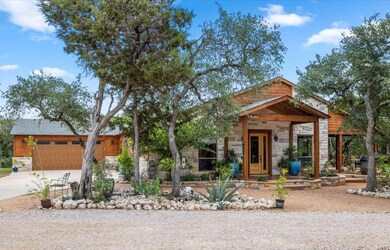 View of front facade with stone siding, driveway,