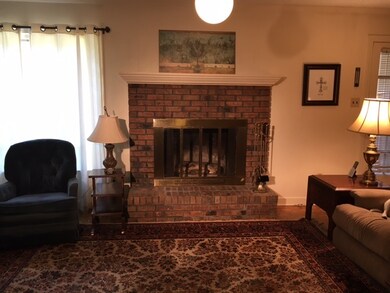Den features hardwood floors and wood burning fire