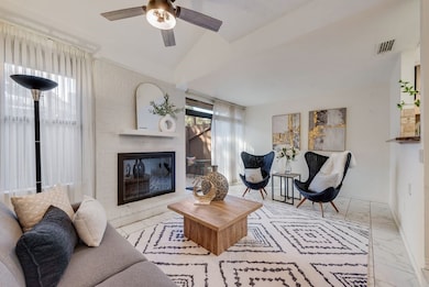 Living area with a brick fireplace, tile flooring with door to patio
