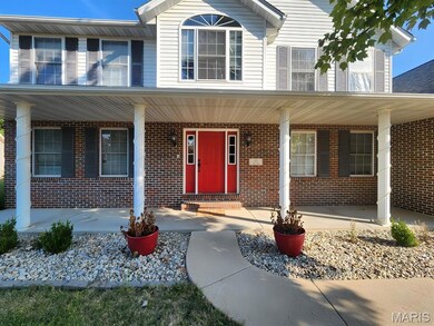 View of exterior entry with brick siding and a porch