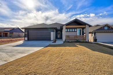 View of front of property with a front yard and a garage