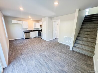 Kitchen with light wood-style flooring, white cabinetry, dark countertops, appliances with stainless steel finishes, and recessed lighting
