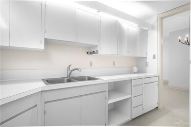 Kitchen with a sink, light countertops, and baseboards