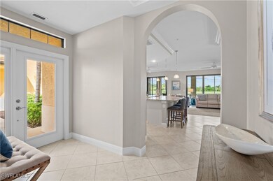 Foyer featuring light tile patterned floors, arched walkways, and a ceiling fan
