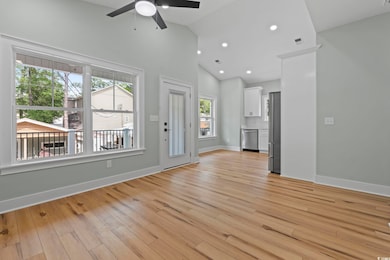Unfurnished living room featuring a ceiling fan, l