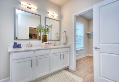 Bathroom with baseboards, double vanity, wood fini