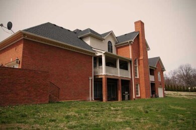 Back view of the sprawling home with two balconies, covered porch (walkout basement) and a fourth garage for antique car or a boat.  Set your 2 and 4 legged kiddos free in this oversized back yard to play for hours! 