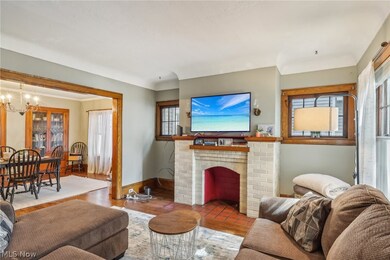 Living room featuring a healthy amount of sunlight, hardwood / wood-style flooring, a chandelier, and a brick fireplace