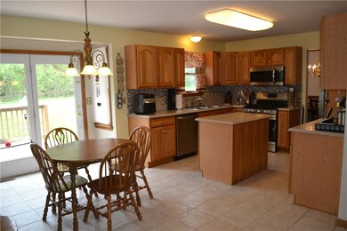Eat-in kitchen features granite countertops, tile backsplash, stainless steel appliances and an island.