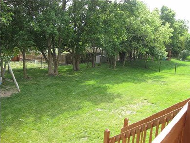 WROUGHT IRON FENCED YARD BACK TO TREES