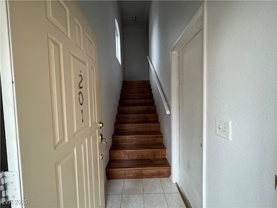 Stairs featuring tile patterned flooring and a textured wall