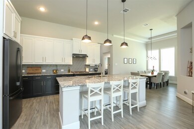 The well-lit island is an ideal spot for quick meals, baking holiday treats, and helping with kids' homework—all while the inviting dining room to the right beckons your family and friends for enjoyable meals together. This space is a vibrant center of activity and practicality, crafted to effortlessly blend everyday convenience with stylish entertainment.