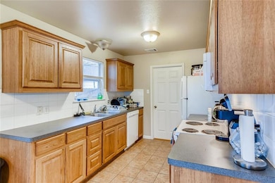 Kitchen with dark countertops, visible vents, whi