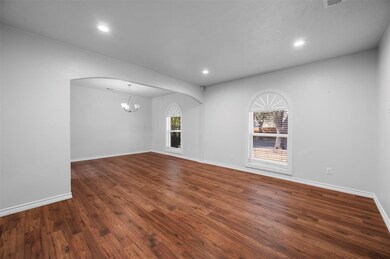 Empty room with arched walkways, recessed lighting