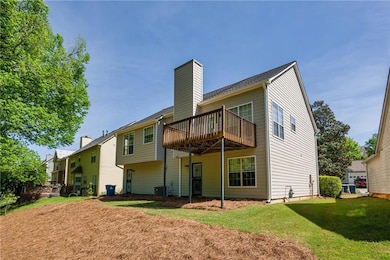 Rear view of property with a wooden deck, a yard, 