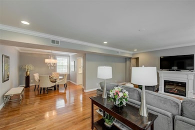 Living room is open to Dining room.  Have you noticed the crown molding, recessed lighting and hardwood floors?