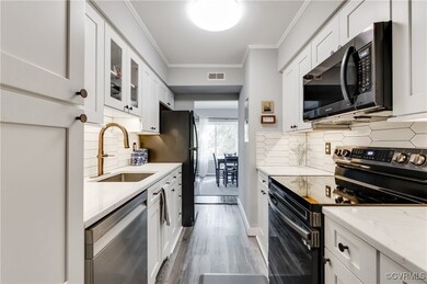 Kitchen with white cabinetry, light wood-type floo
