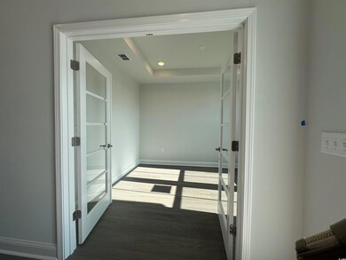 Hall with recessed lighting, visible vents, wood f