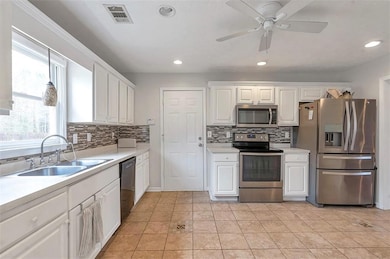 Kitchen featuring white cabinets, visible vents, s