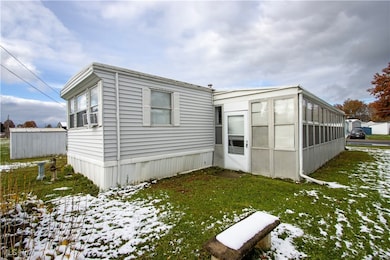 Snow covered property featuring a lawn and a sunroom
