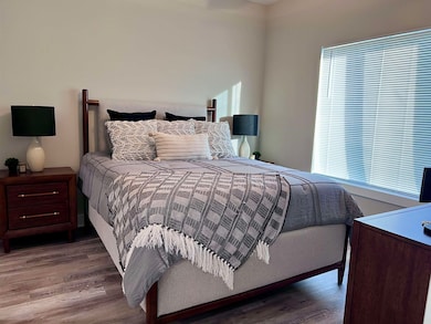 Bedroom featuring multiple windows and wood finished floors