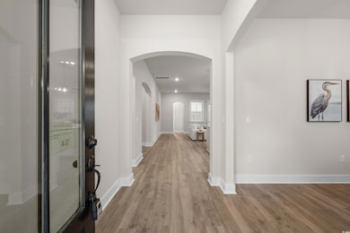 Entrance foyer with arched walkways and wood finished floors