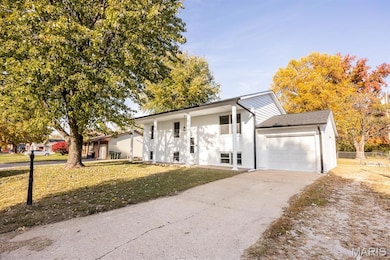 View of front of house with a garage, brick siding, and driveway