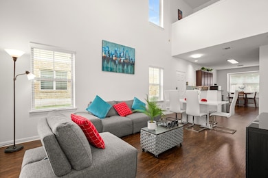 Living area with wood finished floors, a towering
