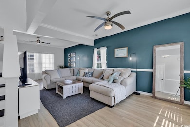 Living area with ornamental molding, baseboards, l