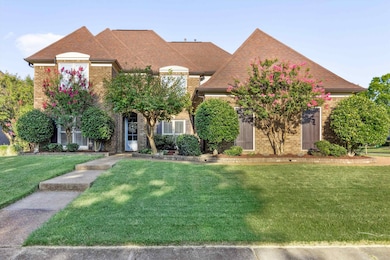 View of front of property featuring brick siding, a front lawn, and roof with shingles