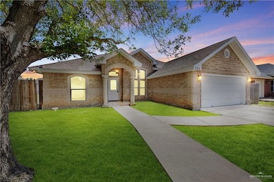 View of front of home with a shingled roof, a garage, driveway, and brick siding