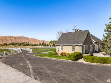 View of side of property with stucco siding, a mountain view, and roof with shingles