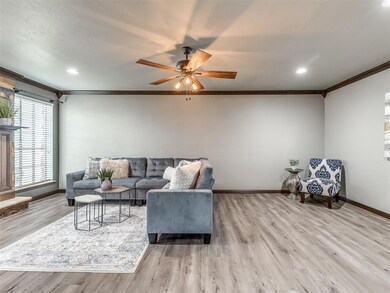 Living room with crown molding, ceiling fan, and light hardwood / wood-style flooring