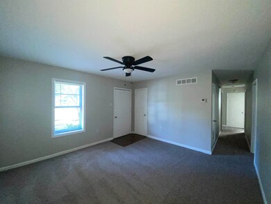Unfurnished bedroom with dark colored carpet, ceil