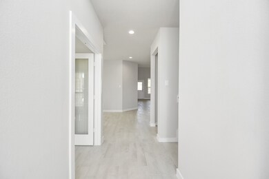 Experience luxury as you step into the threshold of this breathtaking home. The grand entrance beckons with its high ceilings, recessed lighting, and elegant wood-look tile flooring combined with oversized baseboards. Sample photo of completed home with similar floor plan. Actual colors and selections may vary.
