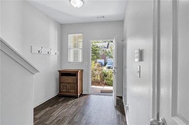 Entrance foyer with dark wood-type flooring and baseboards
