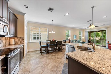 Kitchen featuring ceiling fan with notable chandelier, stainless steel appliances, hanging light fixtures, tasteful backsplash, and light tile floors