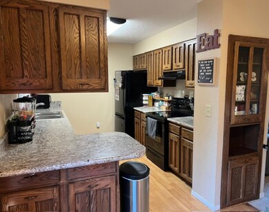 Kitchen with sink, black appliances, light hardwoo