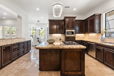 The kitchen carries the rustic Mediterranean feel with rich wood cabinets, ample storage, and a spacious layout for both daily living and entertaining.