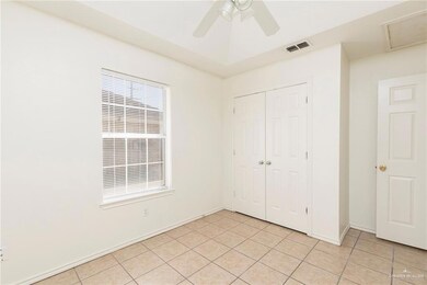 Unfurnished bedroom featuring a closet, light tile patterned flooring, and ceiling fan