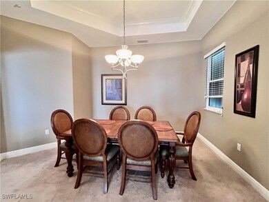 Formal Dining room space with a raised ceiling, a chandelier, light carpet, and crown molding