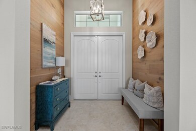Entrance foyer with wood walls, a towering ceiling