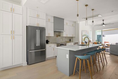 Kitchen featuring wall chimney exhaust hood, ligh