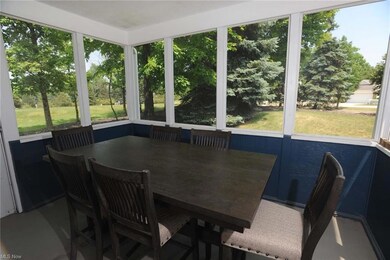 The screened porch is sheltered by trees that provide privacy.