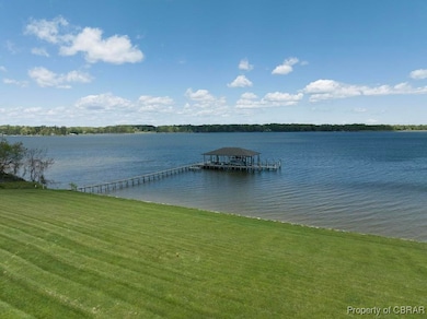 Dock area featuring a lawn, boat lift, and a water