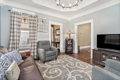 Living room with a tray ceiling, dark wood-type fl