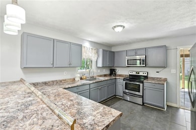 Kitchen with stainless steel appliances, gray cabi