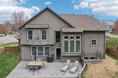 Rear view of property with a lawn, a shingled roof, a fenced backyard, and a patio