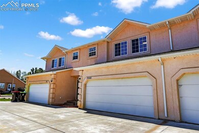 View of property featuring stucco siding and a garage